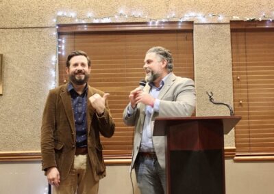 State Representatives Jared Deck and Jacob Rosecrants laughing while standing at a speaker's podium