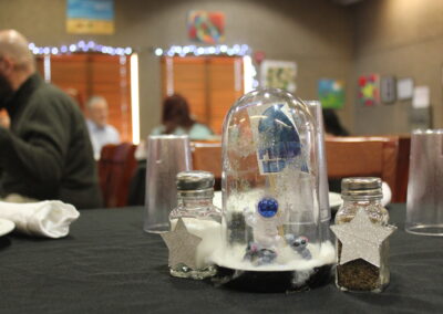 A spaceman suspended in clouds with a miniature planet in a small dome as a centerpiece for the tables at the dinner
